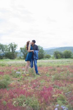 Aşık erkek ve kadın alan kırmızı çiçekli yürüyüş.