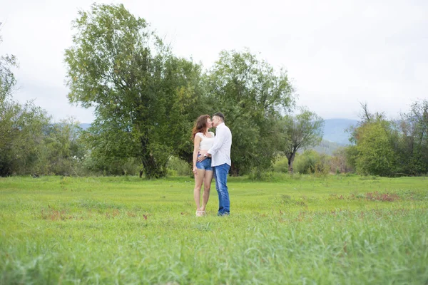 Amantes hombre y mujer caminando en el campo verde . — Foto de Stock