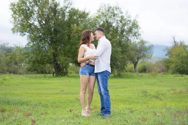 Älskare man och kvinna gå på grönt fält. — Stockfoto