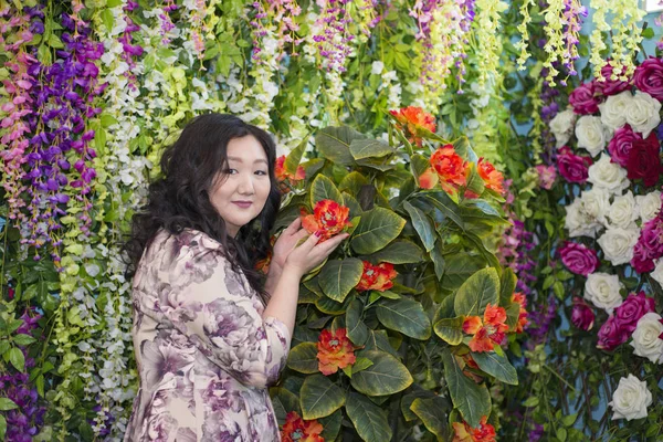 Kobieta pełna Azji w sali z kwiatami. — Zdjęcie stockowe