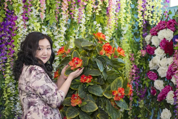 Full Asian woman in the room with flowers. — Stock Photo, Image