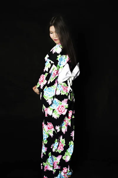 Japanisches Mädchen im traditionellen japanischen Kimono auf schwarzem Hintergrund — Stockfoto