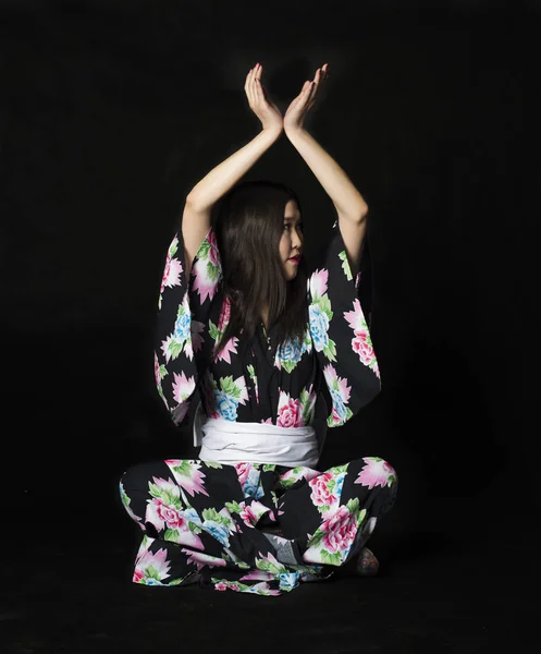Chica japonesa en kimono tradicional japonés sobre fondo negro — Foto de Stock