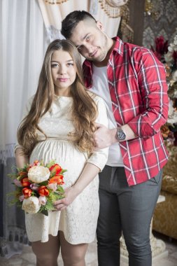 Gelecekteki babası yavaşça onun hamile eşi karnına dokunur.