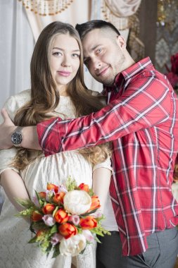 Gelecekteki babası yavaşça onun hamile eşi karnına dokunur.