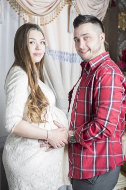 Gelecekteki babası yavaşça onun hamile eşi karnına dokunur.