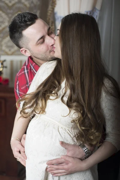 Un dulce beso feliz pareja esperando el nacimiento de su hijo . — Foto de Stock