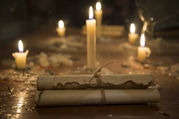 Mysterious ancient scrolls on the table with candles.