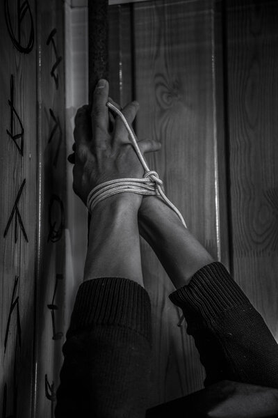 Мужчина со связанными руками, свисающими с потолка
.