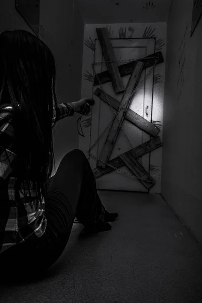 La chica en el pasillo oscuro antes de la última puerta tapiada . —  Fotos de Stock