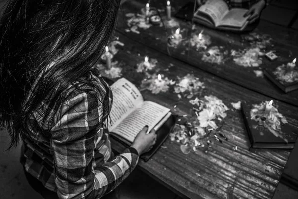 A menina mantém um ritual escuro lendo um feitiço do livro de Sa — Fotografia de Stock