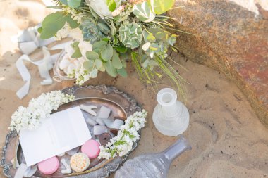 Bir buket ve macaroons stone bir deniz plaj yakınındaki güzel şık dekorasyon. Düğün tasarım