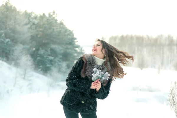 Flicka med fir grenar i skogen på en ljus bakgrund — Stockfoto