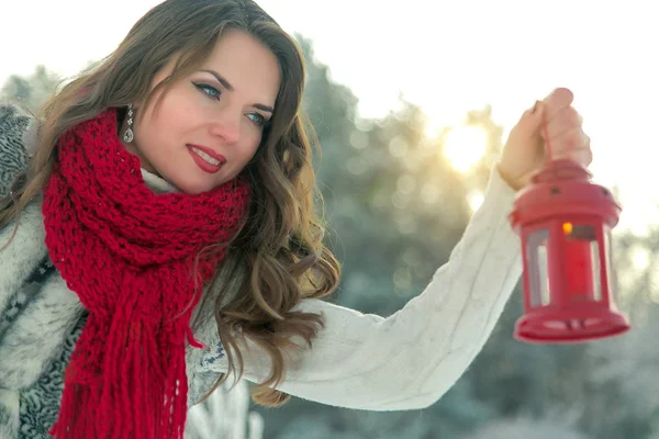Belle jeune femme brune en écharpe tenant une lanterne de Noël rouge avec une bougie — Photo