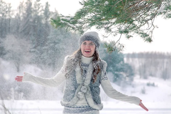 Jeune belle femme souriante jetant de la neige dans les airs pendant les vacances d'hiver — Photo