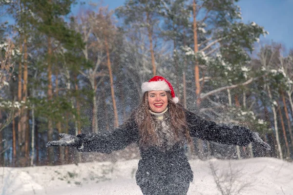 Mladá krásná usměvavá žena házení sněhu ve vzduchu v zimní prázdniny — Stock fotografie