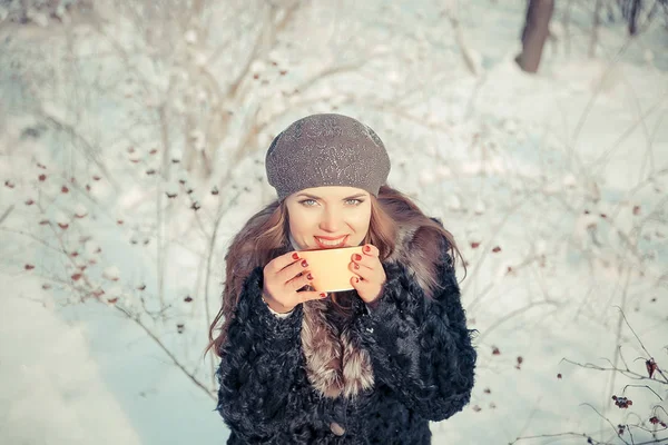 Mladá žena držící šálek s čajem venku v zimě — Stock fotografie