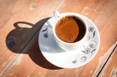 Eski ahşap masa üzerinde bir fincan geleneksel Türk kahvesi