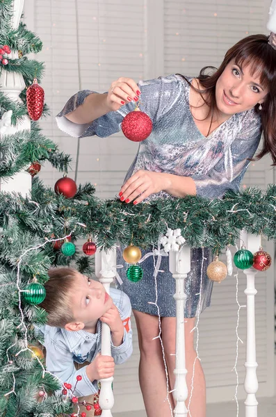 Famille décorant un sapin de Noël avec des boules dans le salon — Photo