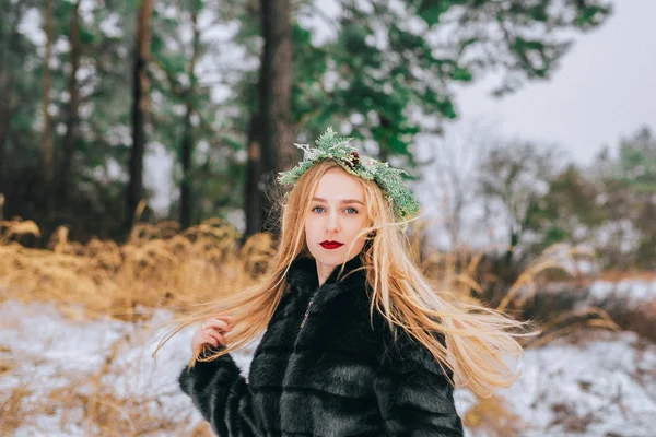 Portrait de la jeune fille dans une couronne d'aiguilles de pin avec leurs longs cheveux blonds est la forêt. Effet rétro photo, grain — Photo