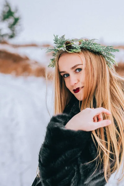 Portrait de la jeune fille dans une couronne d'aiguilles de pin avec leurs longs cheveux blonds est la forêt. Effet rétro photo, grain — Photo