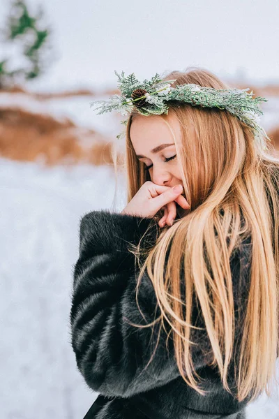Portrait de la jeune fille dans une couronne d'aiguilles de pin avec leurs longs cheveux blonds est la forêt. Effet rétro photo, grain — Photo
