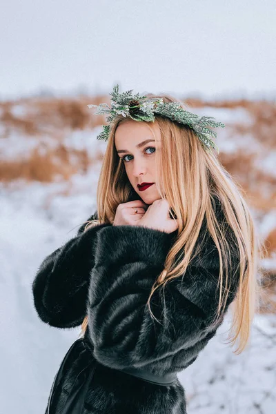 Portrait de la jeune fille dans une couronne d'aiguilles de pin avec leurs longs cheveux blonds est la forêt. Effet rétro photo, grain — Photo