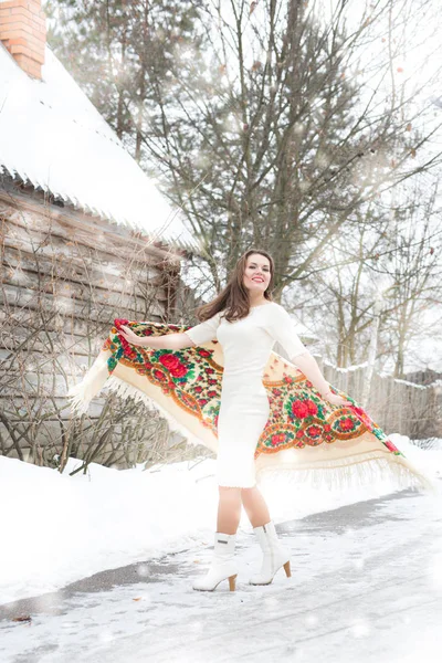 Schönes junges Mädchen mit traditionellem russischem oder ukrainischem Schal im Winter tanzt und feiert. — Stockfoto