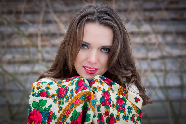 Retrato de cerca de una hermosa joven con una bufanda tradicional rusa o ucraniana en el invierno . — Foto de Stock