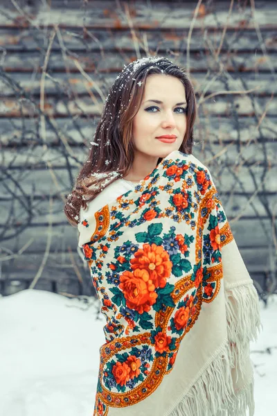 Retrato de cerca de una hermosa joven con una bufanda tradicional rusa o ucraniana en el invierno . —  Fotos de Stock