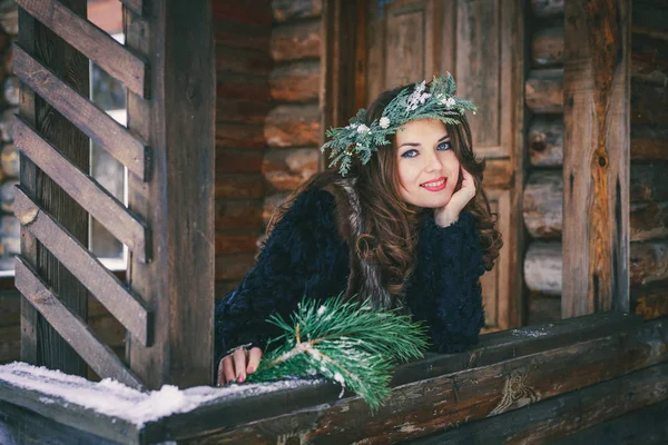 Portret zbliżenie piękna brunetka dziewczyna w wieniec na podłoże drewniane tradycyjny ukraiński lub rosyjski dom. — Zdjęcie stockowe