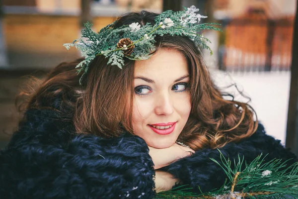 Primer plano retrato de hermosa chica morena en una corona sobre un fondo de madera tradicional ucraniano o ruso casa . — Foto de Stock