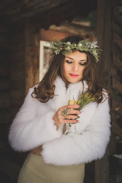 Mooie bruid met glas Champagne buitenshuis op winteravond — Stockfoto