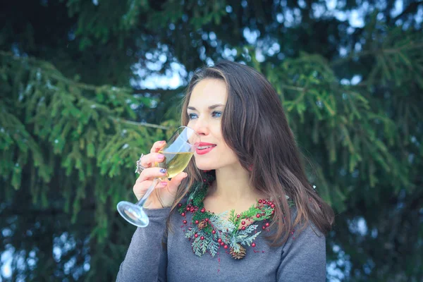 Όμορφη μελαχρινή κοπέλα με ποτήρι σαμπάνια σε εξωτερικούς χώρους σε χειμωνιάτικο απόγευμα — Φωτογραφία Αρχείου