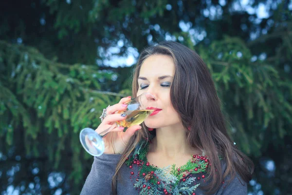 Mooie brunette meisje met glas Champagne buitenshuis op winteravond — Stockfoto