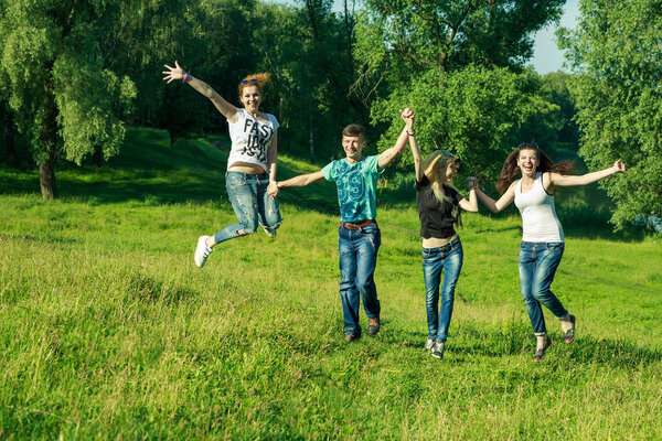 people, freedom, happiness, and teenage concept. group of happy friends wearing sunglasses jumping high grass background