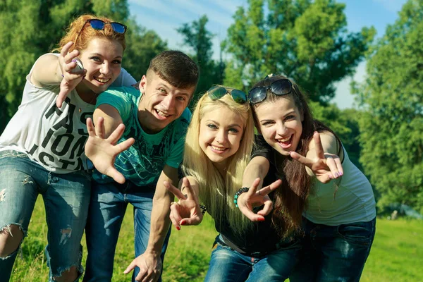Personas, la libertad, la felicidad y el concepto adolescente - grupo de amigos felices salen y se divierten en un fondo de árboles verdes — Foto de Stock