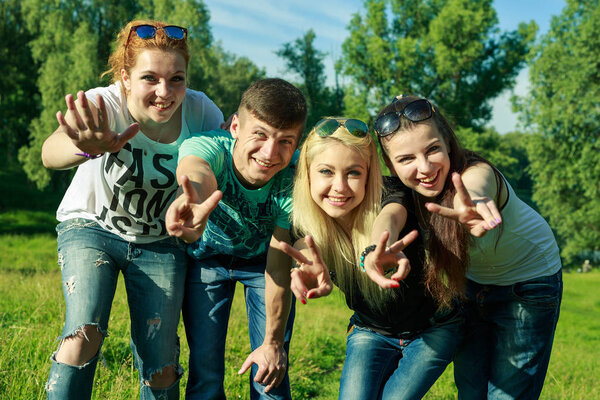 people, freedom, happiness, and teenage concept - group of happy friends go out and fun on a background of green trees