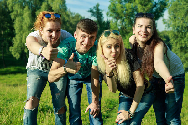 people, freedom, happiness, and teenage concept - group of happy friends go out and fun on a background of green trees