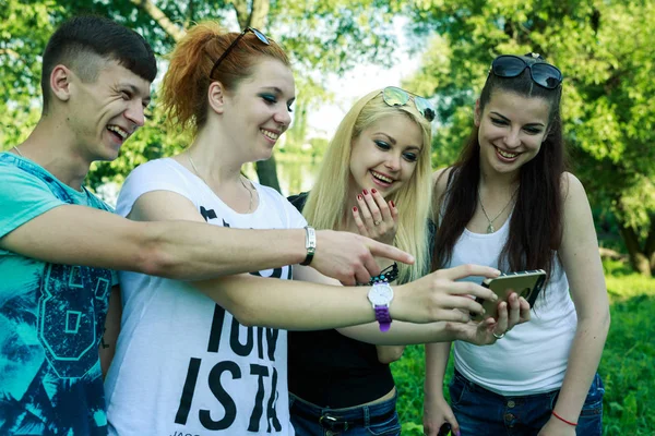 Grupo de jóvenes amigos felices mirando el teléfono celular — Foto de Stock