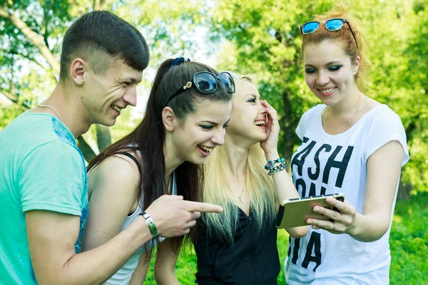 Gruppo di giovani amici felici guardando il telefono cellulare — Foto Stock