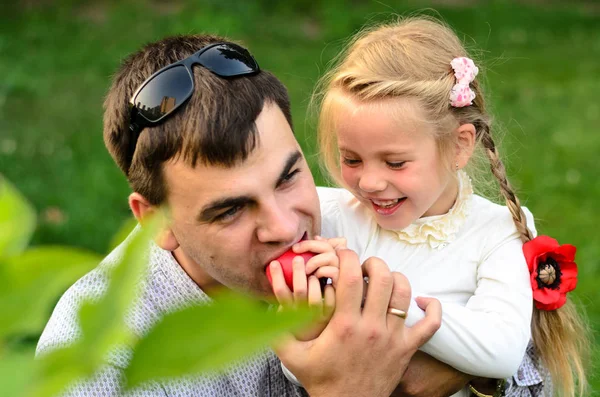 Padre con hija comiendo manzanas juntos . — Foto de Stock