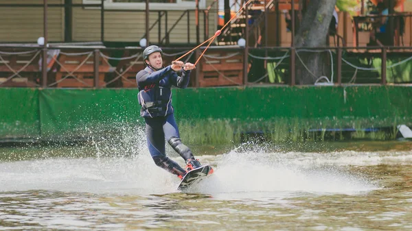 Extreme Park, Kiev, Ucrânia - 07 de maio de 2017 - um jovem praticava salto em Wakeboarding. Foto processamento de grãos . — Fotografia de Stock