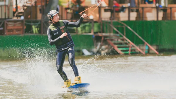 Extreme Park, Kiev, Ucrânia - 07 de maio de 2017 - um jovem praticava salto em Wakeboarding. Foto processamento de grãos . — Fotografia de Stock