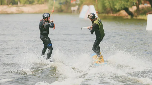 Extreme Park, Kiev, Ukraine, 07 may 2017 - a couple of young men to ride a Wakeboard, do tricks and shoot camera. Photo of grain processing — Stock Photo, Image