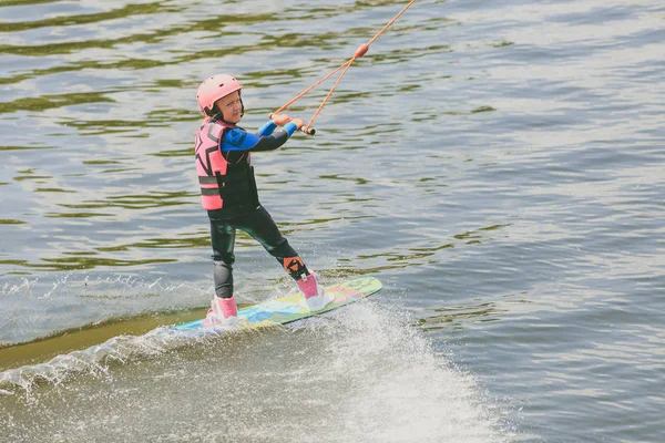 Extreme Park, Kiev, Ucrânia, 07 de maio de 2017 - uma garotinha para montar um Wakeboard. Foto de processamento de grãos — Fotografia de Stock