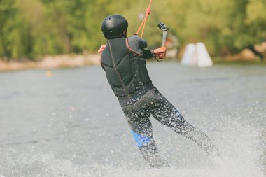 Genç bir adam bir Wakeboard binmek, hile yapmak ve ateş etmek fotoğraf makinesi. Tahıl işleme ait fotoğraf