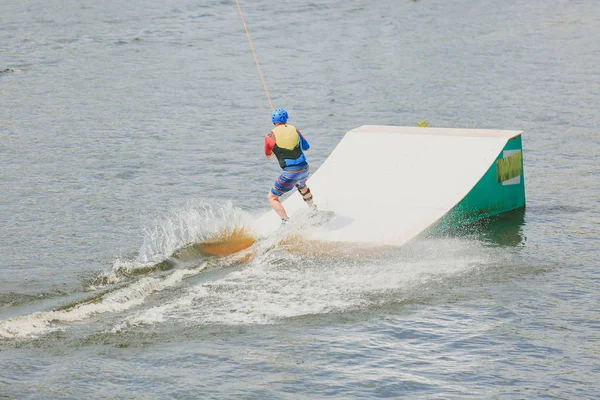 Egy fiatal férfi gyakorolta, jumping, wakeboard. Fotó feldolgozás gabonát. — Stock Fotó