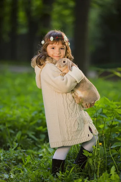 Mooi meisje met een konijn in het bos — Stockfoto