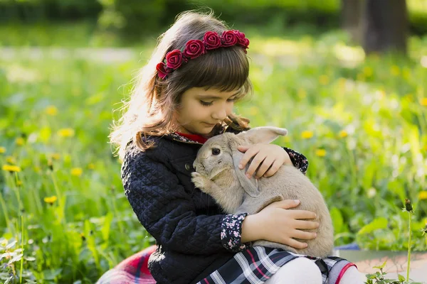 Hermosa chica con un conejo en el bosque — Foto de Stock